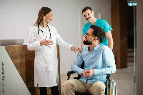 Canvas Print Medical team assisting patient in wheelchair at clinic