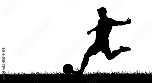 Silhouette of a football player kicking a ball
