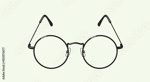 A pair of round, black-rimmed eyeglasses with thin metal arms, presented against a plain, light background.