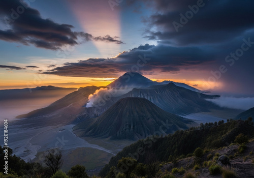 Dramatic sunrise over Mount Bromo volcano with smoking crater crepuscular rays and vibrant sky.
