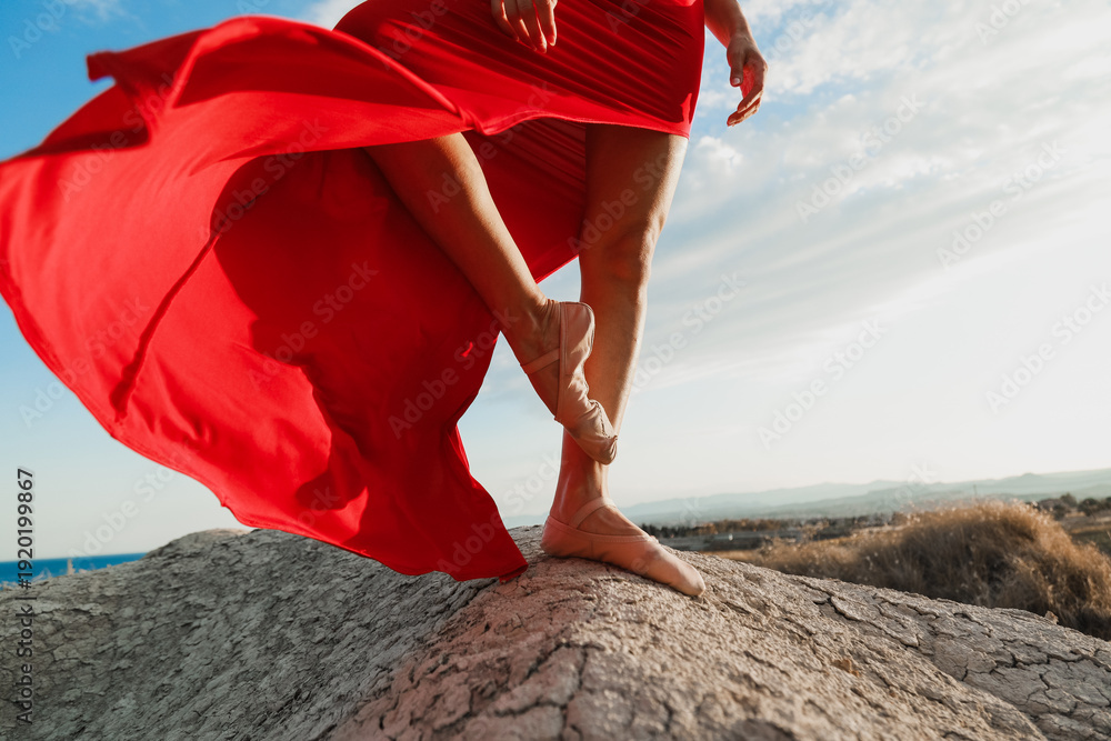 Φωτογραφία Detail of red dress flowing with dance shoes on rocky ground
