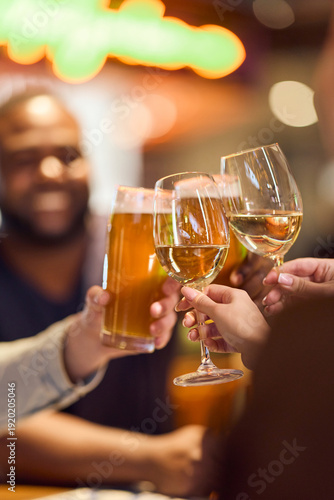 Friends Toast Together With Wine And Beer Glasses In A Warm Bar Celebration