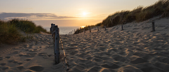 Foto auf Acrylglas Nordsee View of sunset over the North Sea from a path on the edge of the dune in Zandvoort, Netherlands  © Matt A. Hawk