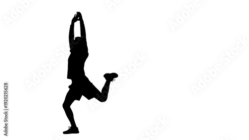 Silhouette of a person performing a dynamic stretching exercise.