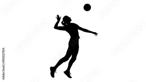 Silhouette of a female volleyball player spiking the ball with power.