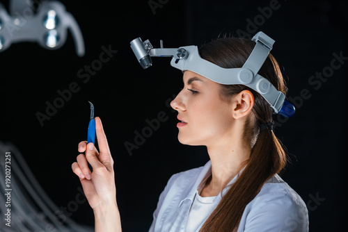 Obraz na plátne Female Surgeon Inspecting Surgical Instrument In Hand, Evaluating Tip And Balanc