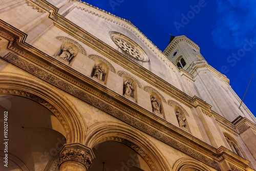 Interior of grand church with congregation and illuminated altar mural