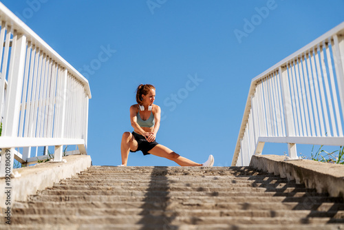 Tableau sur toile Fit woman exercising on top of a staircase outdoors in summer