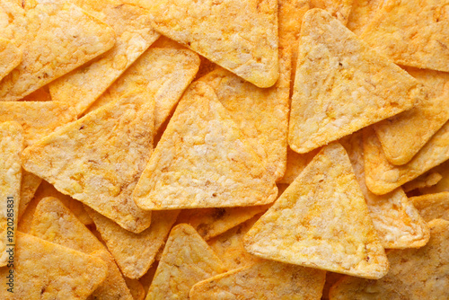 Triangular corn chips background. Top view