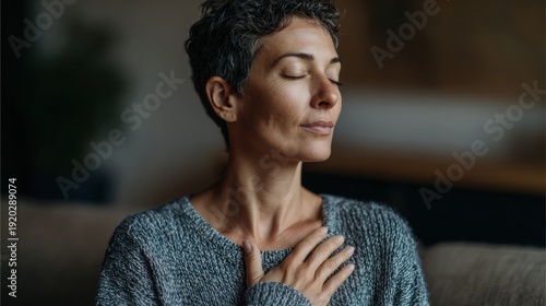 Wallpaper Mural Woman closed eyes hand on chest sitting on couch practicing grounding breath at home, soft ambient light, short haircut, peaceful expression, postwork relaxation and nightly self regulation Torontodigital.ca