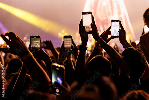 Audience Members Holding up Phones to Film a Live Performance at an Arena