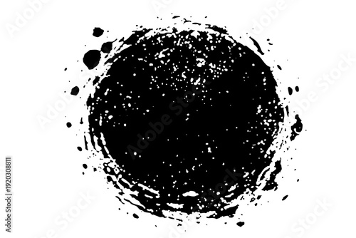 Black circular splash with uneven edges and spray on white background showing movement and energy in design process