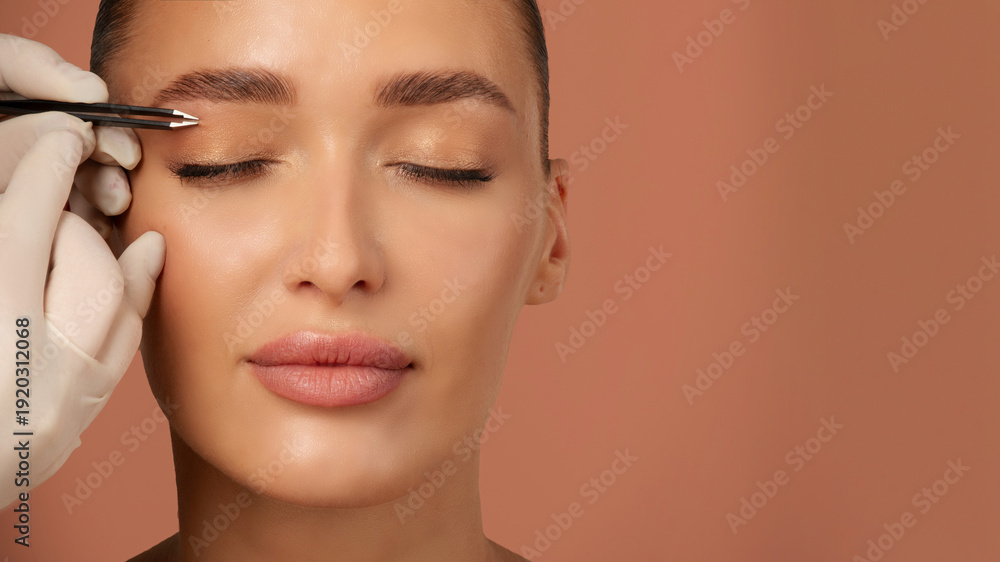 Αυτοκόλλητο Hand holding tweezers and shaping eyebrows to young European woman, beautician p