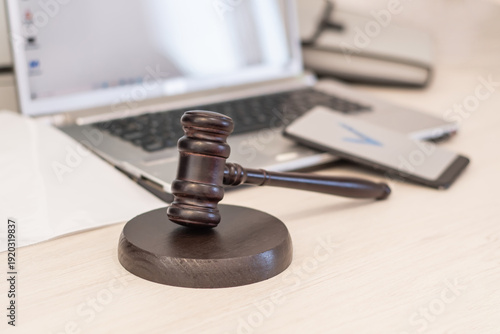A judge's gavel with a laptop and smartphone with an acceptance icon. Workplace of a law firm. Concept of online legal services and digital justice.