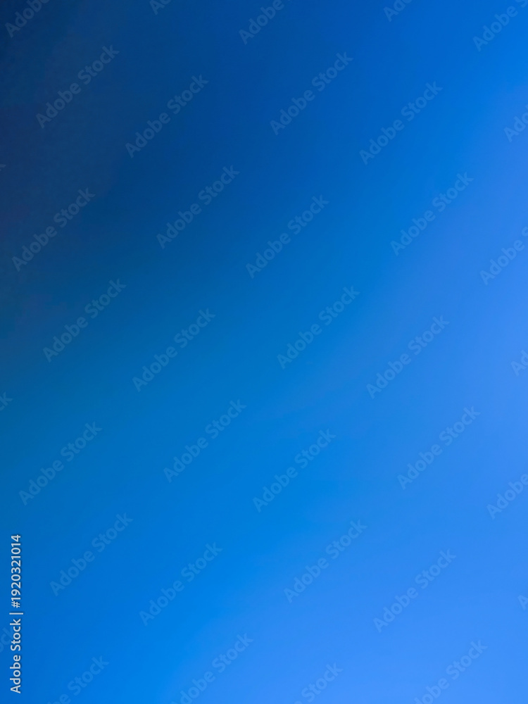 Fototapeta premium The photograph, taken with a camera, has a background color tone of blue and navy. The image contains white with shades of light blue, navy, dark blue, and black, creating a gradient of colors and lig