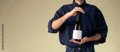 Obraz na plátně Sparkling wine bottle mockup banner blank label navy shirt ochre background