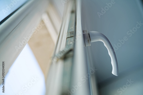 Принти на полотні Low angle view of an open uPVC window sash with a handle and metal locking mechanism