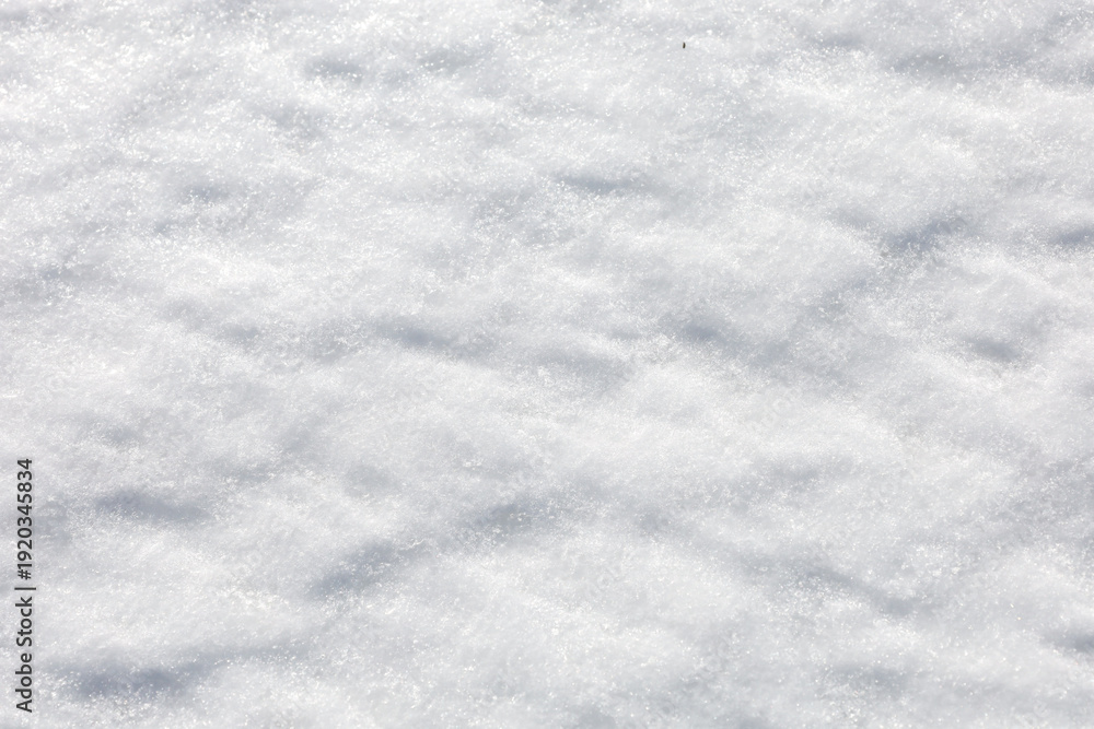 Obraz premium Pure white snow surface sparkles under bright winter sun, creating a soft texture with gentle shadows and icy crystals.