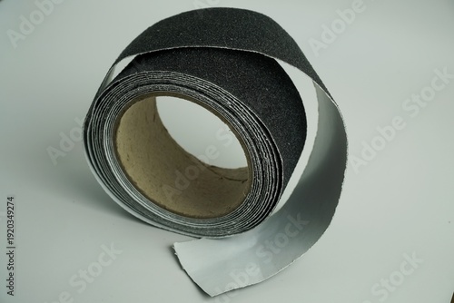 Fotografie Close-up of a roll of black anti-slip tape with a textured surface, useful for e