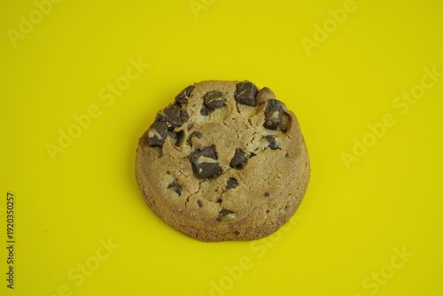 Cuadro en lienzo Delicious chocolate chip cookie on a bright yellow background, a sweet treat