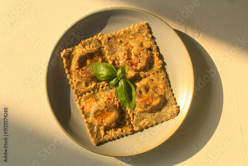 Photos Homemade ravioli pasta with basil leaf on top. Pasta plating.