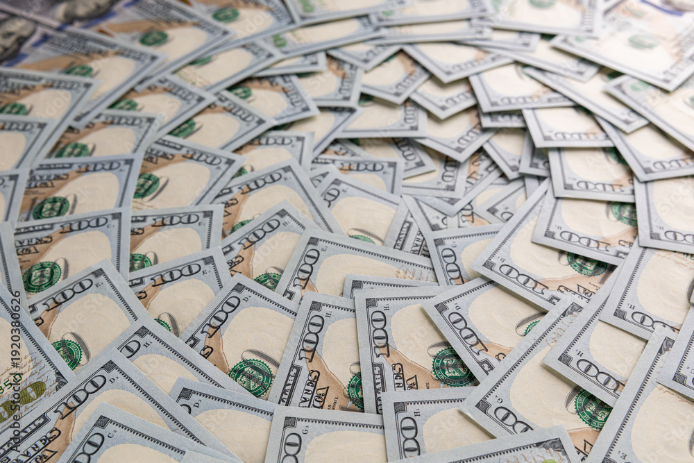 Fototapeta premium Background of Scattered One Hundred US Dollar Bills Representing Wealth and Finance