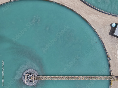 Aerial view of turquoise waters swirling within circular ponds, connected by a slender bridge, creating a striking geometric pattern against the arid landscape, Phoenix, Arizona, United States.