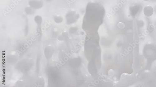 Milk Splashing in Slow Motion and Macro - Abstract White Energetically Bouncing Fluid Makes Droplets and Splashes