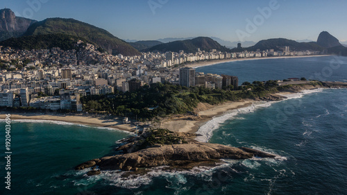 Aerial view of the coastline meeting the city, with iconic mountains in the background, creating a harmonious blend of nature and urban life, Rio de Janeiro, State of Rio de Janeiro, Brazil.