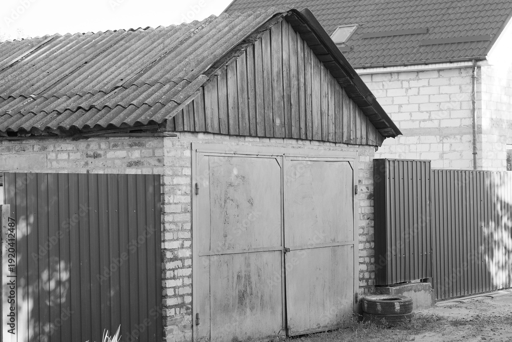Fototapeta premium gray brick wall garage facade with metal gates on the street