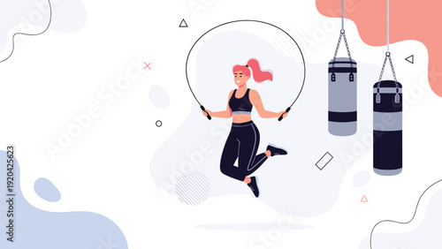 Energetic woman skipping rope in modern gym environment with boxing equipment for cardio and fitness training.