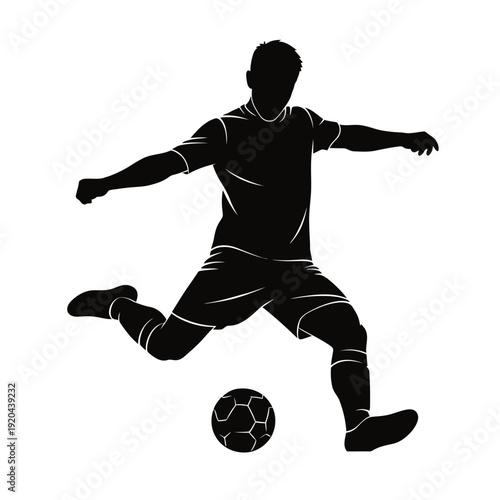 Silhouette of a soccer player kicking a ball