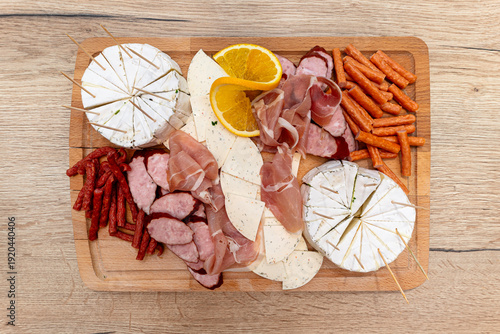 Charcuterie board with cheese, various dried sausages, and ham