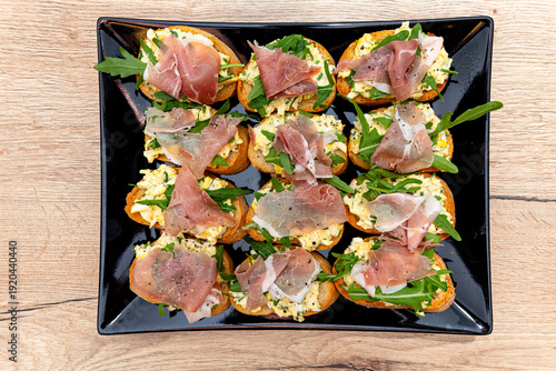Savory bruschetta with egg paste, arugula, and smoked ham
