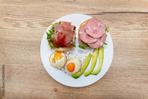 Kaiser rolls with ham, fried eggs, avocado, and rocket