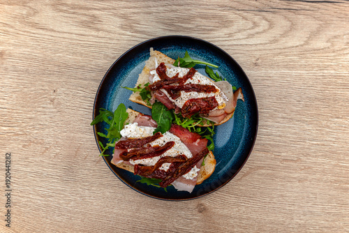 Baguette crostini with burrata, smoked ham, dried tomatoes, arugula