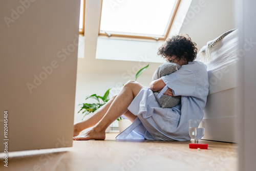 Middle aged white woman hugging pillow during seasonal depression episode