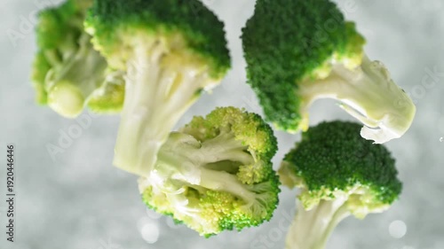 Broccoli Florets Falling Into Pot Of Boiling Water Making a Splash In Slow Motion, Table Top View