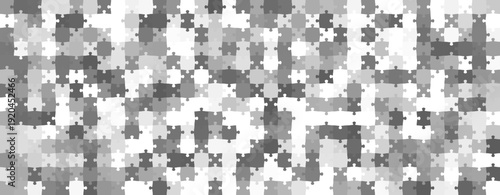 Abstract monochrome mosaic background with interlocking puzzle pieces, grey geometric texture for wide web banner