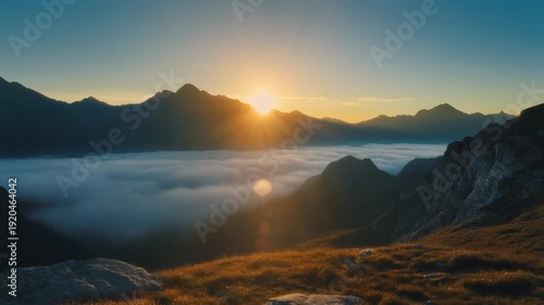 Serene mountain landscape at sunrise with sun rays breaking through clouds over a misty valley
