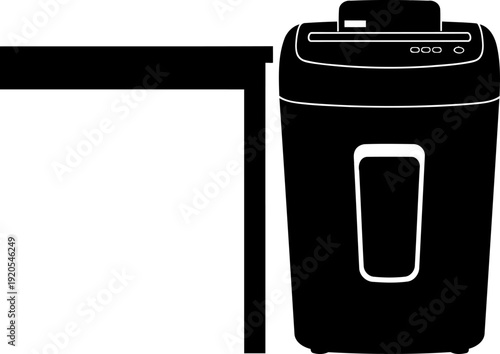 Office paper shredder placed beside a desk surface