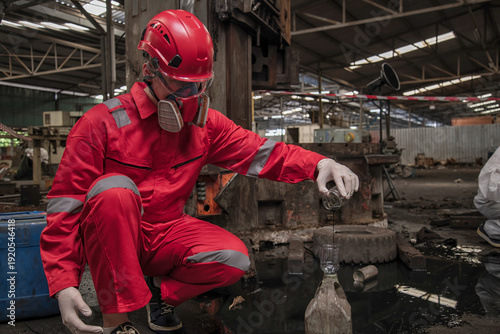 person in mask. Hazardous control related to factory chemicals. Employees are disposing of harmful substances. in a chemical protective suit in a factory