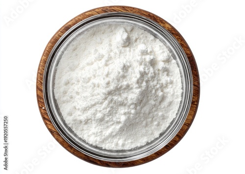 Overhead shot of a glass jar filled with white powder, set inside a wooden bowl