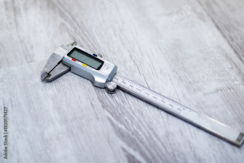 Foto Accurate digital device assesses metal dimensions on wooden base for quality con