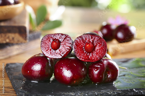 Fresh Dark Red Cherries Cut in Half on Black Slate Board - Healthy Organic Summer Fruit