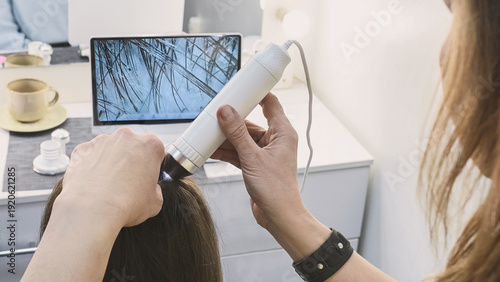 Fotografía Trichologist examines hair and scalp of young woman in salon using trichoscope and dermatoscope