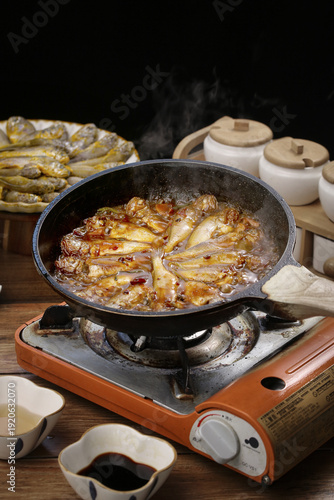 Fotografie Braised Fish Cooking in Wok on Gas Stove - Traditional Asian Cuisine Preparation