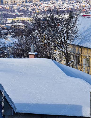 Rooftops of city houses buried under heavy white winter snow