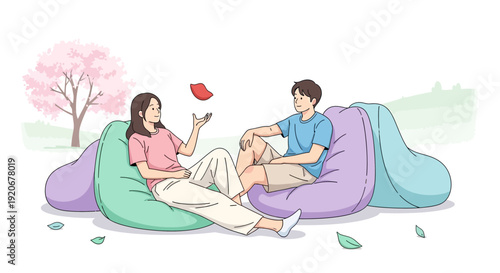Joyful Couple Relaxing Outdoors on Beanbags Under Cherry Blossoms