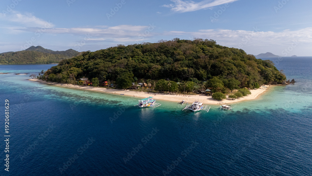 Naklejka premium Drone Aerial view of Banana Island, a tropical beach with turquoise water, white sand, and a bangka boat in Coron, Palawan, Philippines